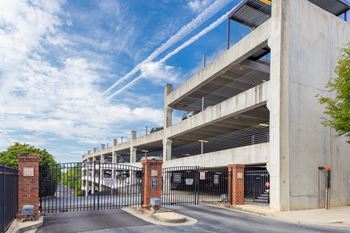 A parking garage with a black gate in front.